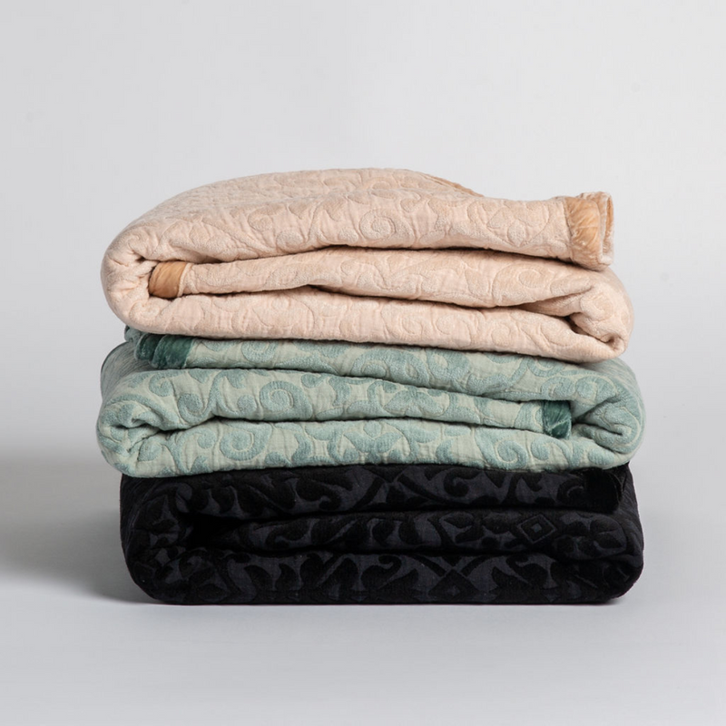 Vienna Blanket | A stack of three cotton jacquard throw blankets against a white background.
