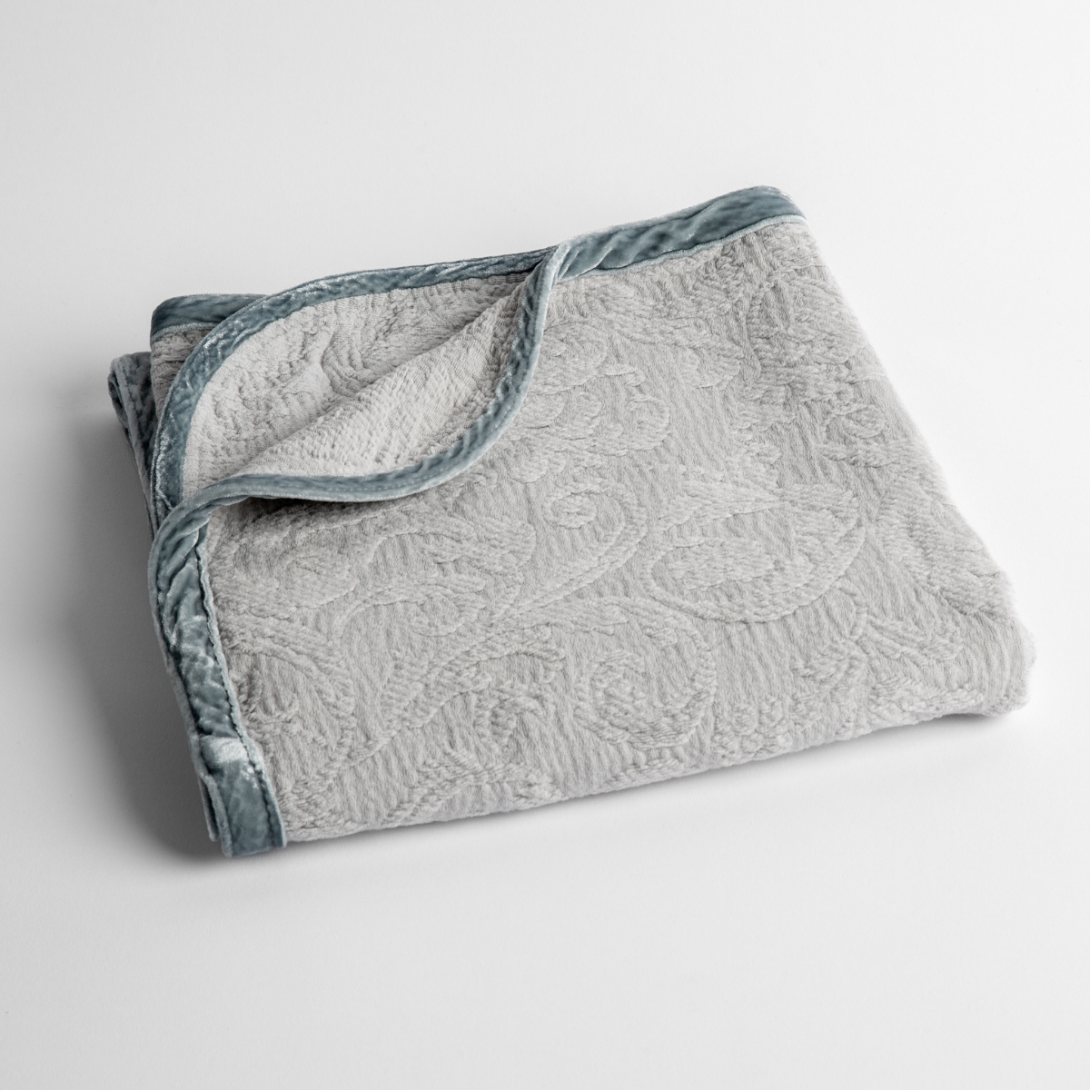 Adele Baby Blanket | Cloud | a folded blanket with the corner turned down to show the trim against a white background, shot from an overhead angle.