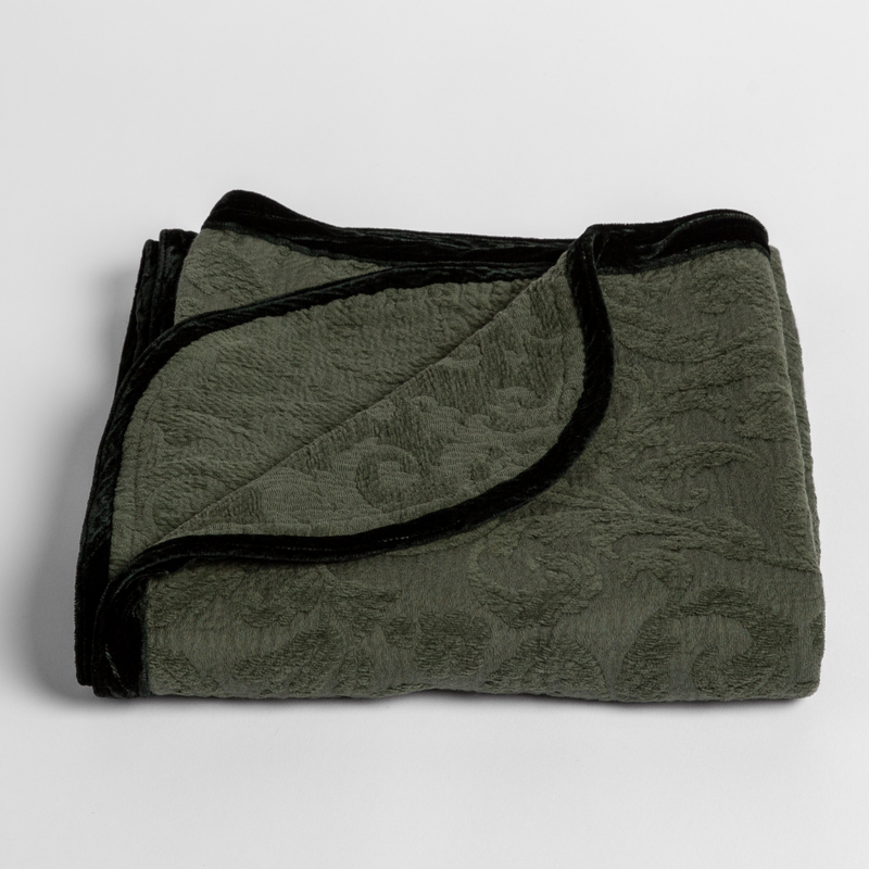 Adele Baby Blanket | Juniper | a folded blanket with the corner turned down to show the trim against a white background, shot from an overhead angle.