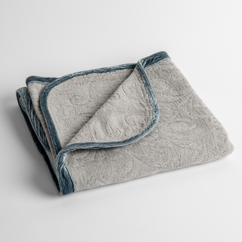 Adele Baby Blanket | Mineral | a folded blanket with the corner turned down to show the trim against a white background, shot from an overhead angle.