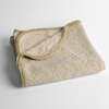 Adele Baby Blanket | Parchment | a folded blanket with the corner turned down to show the trim against a white background, shot from an overhead angle.