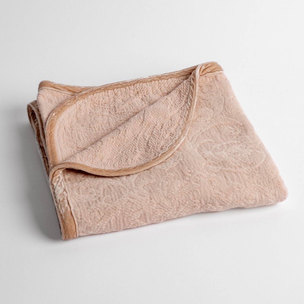 Adele Baby Blanket | Pearl | a folded blanket with the corner turned down to show the trim against a white background, shot from an overhead angle.