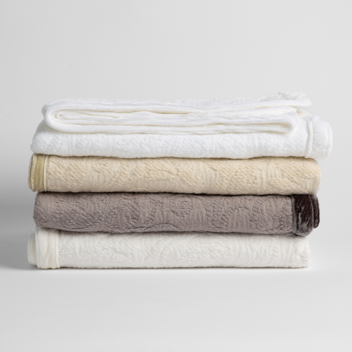 Adele Baby Blanket | a stack of four organic cotton baby blankets in white, parchment, moonlight and winter white.  against a white background.