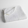 Adele Baby Blanket | White | a folded blanket with the corner turned down to show the trim against a white background, shot from an overhead angle.