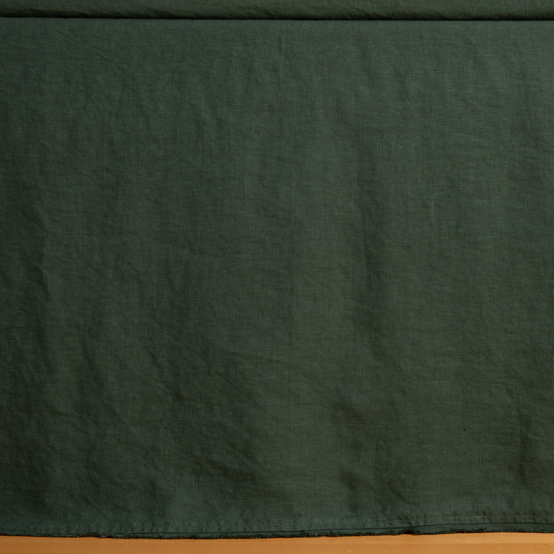 Austin Bed Skirt | Juniper | a close up of a midweight linen bed skirt barely skimming the floor.