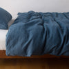 Austin Duvet Cover | Midnight | Midweight linen duvet cover in midnight on a bed, side view.