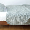 Austin Coverlet | Eucalyptus | Quilted midweight linen coverlet in eucalyptus on a bed - side view.