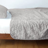 Austin Coverlet | Fog | Quilted midweight linen coverlet in fog on a bed - side view.