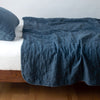 Austin Coverlet | Midnight | Quilted midweight linen coverlet in midnight on a bed - side view.