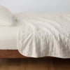 Austin Coverlet | Parchment | Quilted midweight linen coverlet in parchment on a bed - side view.