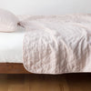 Austin Coverlet | Pearl | Quilted midweight linen coverlet in pearl on a bed - side view.