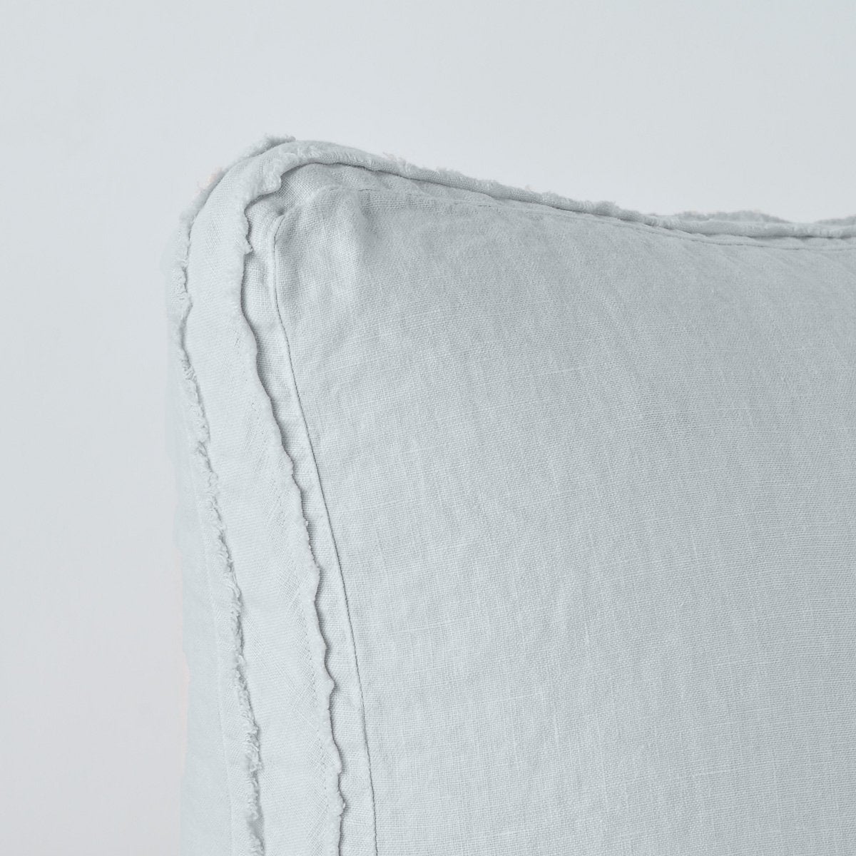 Cloud | Close-up angle of the corner of an Austin sham, highlighting the raw edge trim on either side of the gusset.