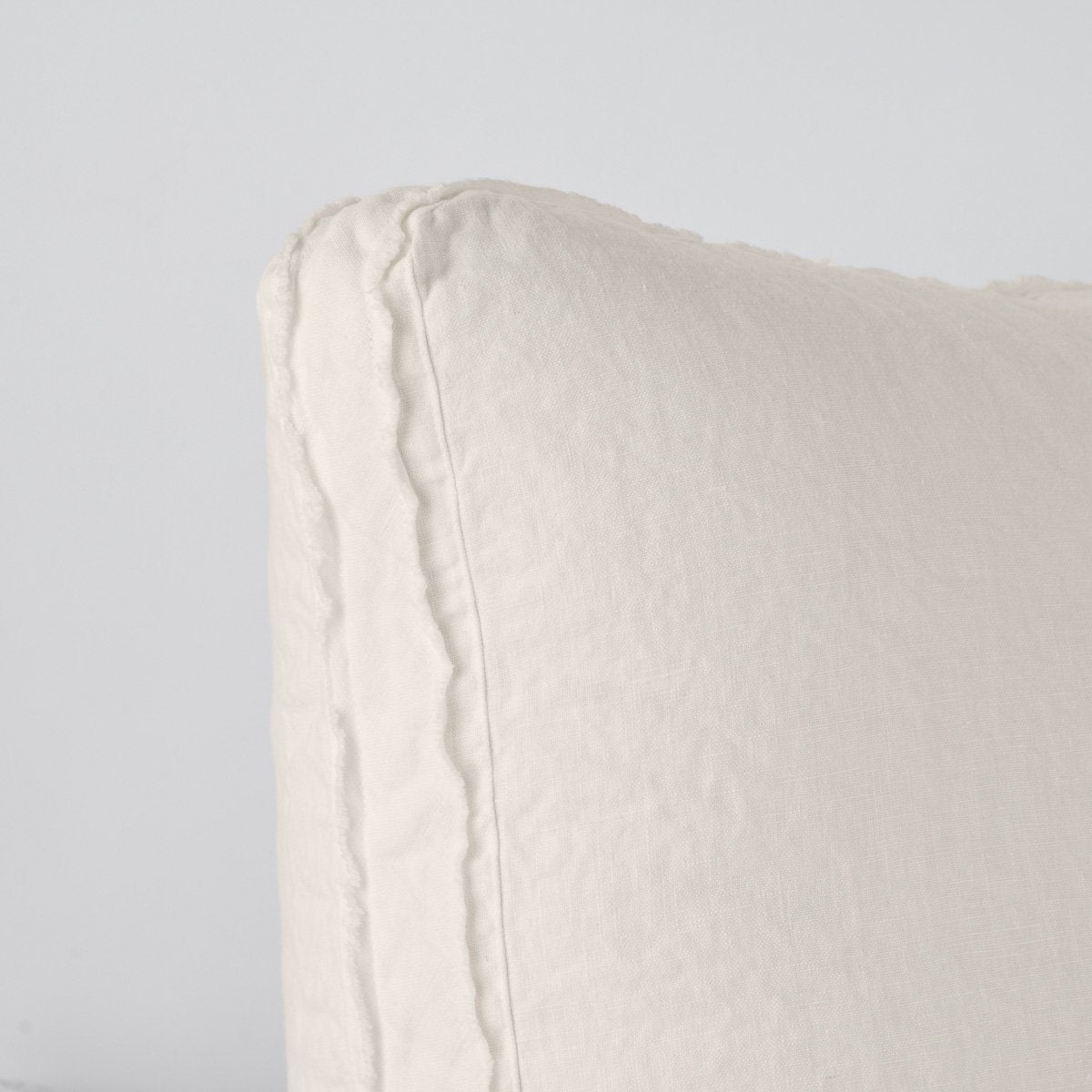 Parchment | Close-up angle of the corner of an Austin sham, highlighting the raw edge trim on either side of the gusset.