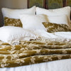 Winter white Austin shams layered behind winter white linen with cotton lace and rich gold embroidered silk velvet.