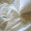 Frida Flat Sheet | Close up of Frida lace detail in winter white flat sheet and matching pillowcase, highlighting the antique cotton lace pattern - overhead view.