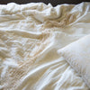 Lynette Blanket | Lynette's gold embroidery in winter white beautifully complements our linen with cotton lace in the same hue - close-up overhead angle.