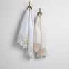 Mattine Guest Towel | two linen with lace guest towels in white and winter white on decorative towel hooks mounted on a white wall.