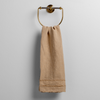 Austin Guest Towel | Honeycomb | midweight linen guest towel with raw edge band at both ends hanging from a towel ring mounted to a white wall.