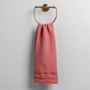 Austin Guest Towel | Poppy | midweight linen guest towel with raw edge band at both ends hanging from a towel ring mounted to a white wall.