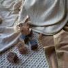 Vienna Baby Blanket | three baby blankets strewn on the floor with wooden toys scattered on a braided rug.