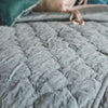 Harlow Coverlet | Mineral | Close-up of Harlow quilted coverlet in mineral, with pops of green and pink throw pillows in the top of the frame - overhead angle.