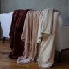 Adele Blanket | three throw blankets draped over the back of a white sofa. The adele throw blanket is on the far left in Mahogany.