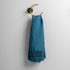 Mattine Guest Towel | Cenote | linen with mattine lace trimmed guest towel on a decorative towel ring mounted on a white wall.