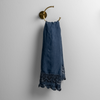 Mattine Guest Towel | Midnight | linen with mattine lace trimmed guest towel on a decorative towel ring mounted on a white wall.