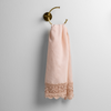 Mattine Guest Towel | Pearl | linen with mattine lace trimmed guest towel on a decorative towel ring mounted on a white wall.