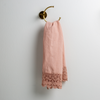 Mattine Guest Towel | Rouge | linen with mattine lace trimmed guest towel on a decorative towel ring mounted on a white wall.