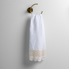 Mattine Guest Towel | White | linen with mattine lace trimmed guest towel on a decorative towel ring mounted on a white wall.