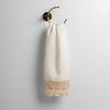 Mattine Guest Towel | Winter White | linen with mattine lace trimmed guest towel on a decorative towel ring mounted on a white wall.