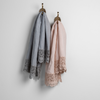 Mattine Guest Towel | pair of linen guest towels with mattine lace hanging from decorative towel hooks against a white wall - mineral and pearl.