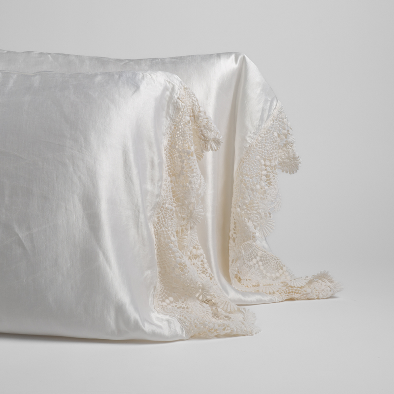 Paloma Pillowcase (Single) | White | charmeuse with lace trimmed pillowcases standing upright against a white background.