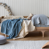 Carmen Baby Blanket | Rumpled blanket in cloud layered over a toddler bed in cream and blue grey tones, in a bright nursery with warm wood accents.