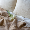 Ines Bedspread | Close up of rumpled bedspread in honeycomb, shown with white fresh flowers and creamy white cotton lace.