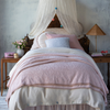 Linen Twin Bed Skirt | Bed skirt in pearl on a twin bed, layered under a creamy duvet and cotton chenille blanket, highlighting the gathered style of the linen - end of bed view.
