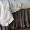 Linen Whisper Crib Skirt | Close up of crib skirt in moonlight under soft floral crib bedding showcases the gathering of the linen and the ruffle trim.
