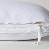 Harlow Throw Pillow | White | Close-up of charmeuse gusset, raw-edge trim, and brass zipper detail on Harlow pillow - side view.