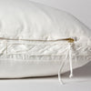Harlow Throw Pillow | Winter White | Close-up of charmeuse gusset, raw-edge trim, and brass zipper detail on Harlow pillow - side view.