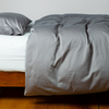 Bria Duvet Cover | Moonlight | duvet cover and matching sleeping pillow on white sheeting - side view.