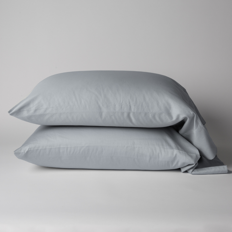 Bria Pillowcase (Single) | Cloud | Two cotton sateen sleeping pillows, stacked neatly against a white backdrop - side view.