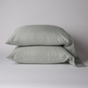 Bria Standard Pillowcase (Single) | Eucalyptus | Two cotton sateen sleeping pillows, stacked neatly against a white backdrop - side view.