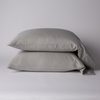 Bria Standard Pillowcase (Single) | Fog | Two cotton sateen sleeping pillows, stacked neatly against a white backdrop - side view.