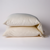 Bria Standard Pillowcase (Single) | Parchment | Two cotton sateen sleeping pillows, stacked neatly against a white backdrop - side view.