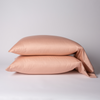 Bria Pillowcase (Single) | Rouge | Two cotton sateen sleeping pillows, stacked neatly against a white backdrop - side view.