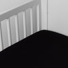 Bria Crib Sheet | Corvino | Cotton sateen crib sheet shown from a slight overhead angle into  an inside corner of a crib.