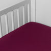 Bria Crib Sheet | Fig | Cotton sateen crib sheet shown from a slight overhead angle into  an inside corner of a crib.