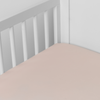 Bria Crib Sheet | Pearl | Cotton sateen crib sheet shown from a slight overhead angle into  an inside corner of a crib.