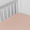 Bria Crib Sheet | Rouge | Cotton sateen crib sheet shown from a slight overhead angle into  an inside corner of a crib.